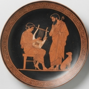 Home Assiette noire à décor cuivre : musicien à la lyre face à un vieillard drapé, chien, frise de méandres.